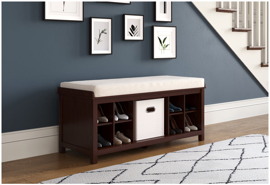 Espresso John Louis Home entryway bench situated in stairwell hallway keeping shoes and items organized